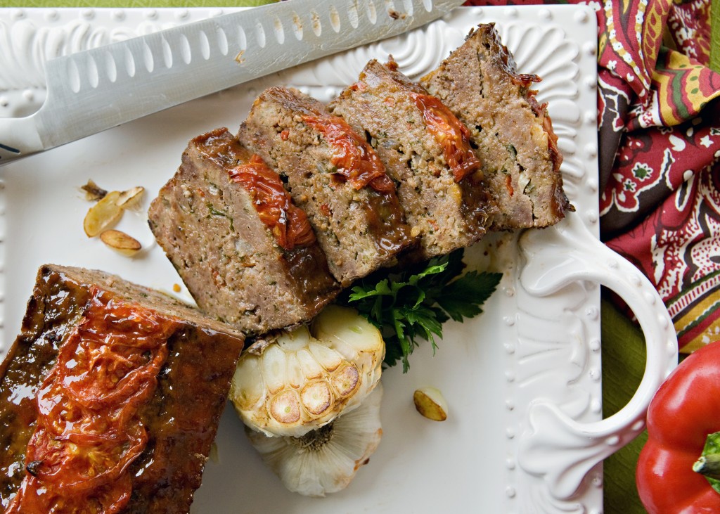 white platter with slices of meatloaf with tomato glaze