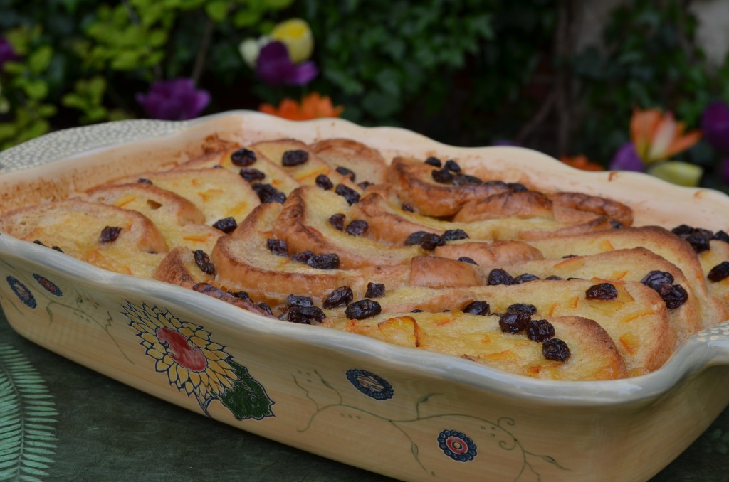 a yellow ceramic dish with a sunflower on it, filled with marmalade bread pudding