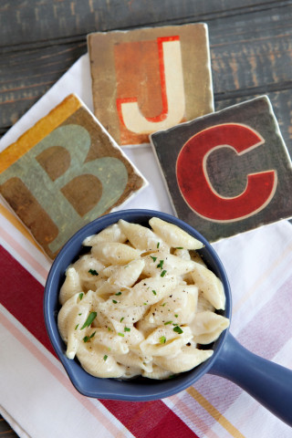 Mac and Cheese in a blue handled bowl with "B", "J", "C" coasters
